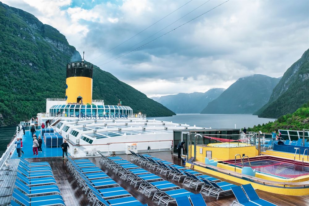 Cruise ship pool deck in a Norwegian fjord among steep mountains